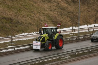 DAUGAVPILS, LATVIA - 5 Şubat 2024: Letonya 'da köylü protestosu. Traktörler, arabalar, tarım makineleri şehrin sokaklarında geziniyor.