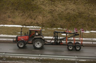 DAUGAVPILS, LATVIA - 5 Şubat 2024: Letonya 'da köylü protestosu. Traktörler, arabalar, tarım makineleri şehrin sokaklarında geziniyor.