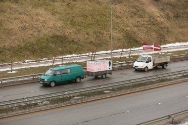DAUGAVPILS, LATVIA - 5 Şubat 2024: Letonya 'da köylü protestosu. Traktörler, arabalar, tarım makineleri şehrin sokaklarında geziniyor.