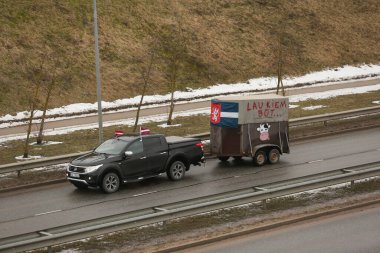 DAUGAVPILS, LATVIA - 5 Şubat 2024: Letonya 'da köylü protestosu. Traktörler, arabalar, tarım makineleri şehrin sokaklarında geziniyor.