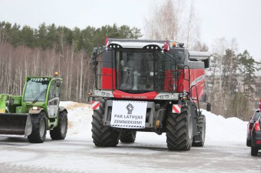 DAUGAVPILS, LATVIA - 5 Şubat 2024: Letonya 'da köylü protestosu. Traktörler, arabalar, tarım makineleri şehrin sokaklarında geziniyor.