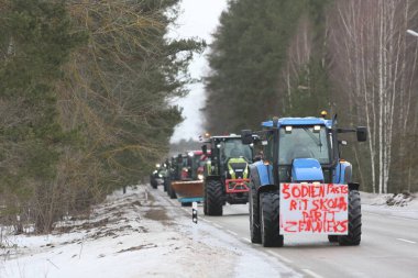 DAUGAVPILS, LATVIA - 5 Şubat 2024: Letonya 'da köylü protestosu. Traktörler, arabalar, tarım makineleri şehrin sokaklarında geziniyor.
