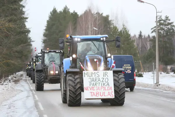 DAUGAVPILS, LATVIA - 5 Şubat 2024: Letonya 'da köylü protestosu. Traktörler, arabalar, tarım makineleri şehrin sokaklarında geziniyor.