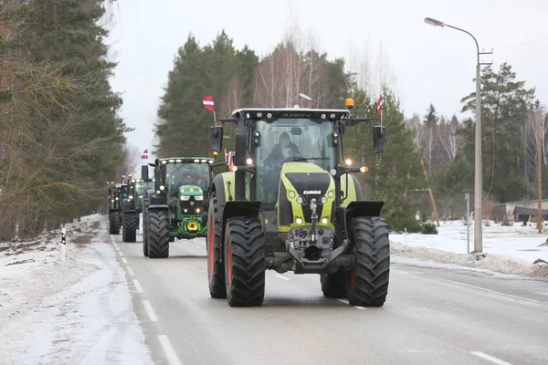 DAUGAVPILS, LATVIA - 5 Şubat 2024: Letonya 'da köylü protestosu. Traktörler, arabalar, tarım makineleri şehrin sokaklarında geziniyor.