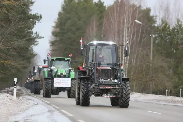 DAUGAVPILS, LATVIA - 5 Şubat 2024: Letonya 'da köylü protestosu. Traktörler, arabalar, tarım makineleri şehrin sokaklarında geziniyor.