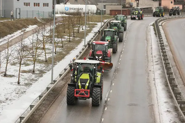 DAUGAVPILS, LATVIA - 5 Şubat 2024: Letonya 'da köylü protestosu. Traktörler, arabalar, tarım makineleri şehrin sokaklarında geziniyor.