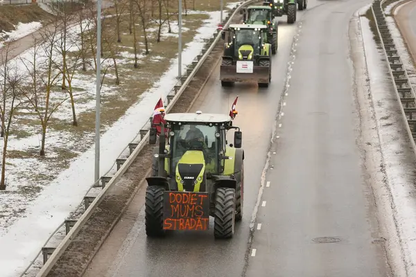 DAUGAVPILS, LATVIA - 5 Şubat 2024: Letonya 'da köylü protestosu. Traktörler, arabalar, tarım makineleri şehrin sokaklarında geziniyor.