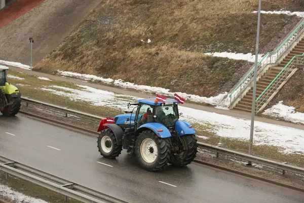 DAUGAVPILS, LATVIA - 5 Şubat 2024: Letonya 'da köylü protestosu. Traktörler, arabalar, tarım makineleri şehrin sokaklarında geziniyor.