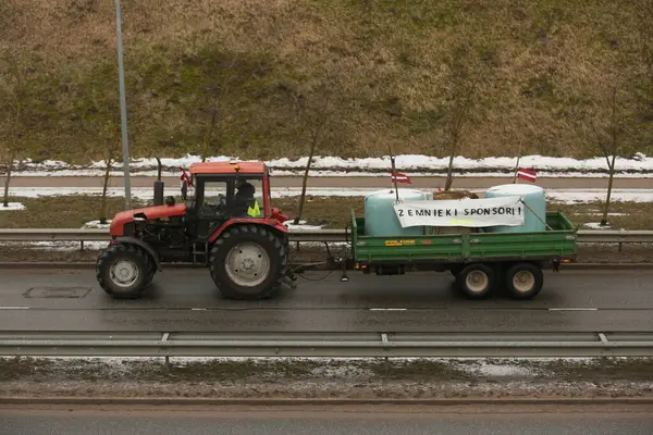 DAUGAVPILS, LATVIA - 5 Şubat 2024: Letonya 'da köylü protestosu. Traktörler, arabalar, tarım makineleri şehrin sokaklarında geziniyor.
