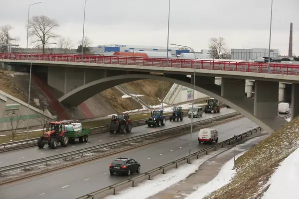 DAUGAVPILS, LATVIA - 5 Şubat 2024: Letonya 'da köylü protestosu. Traktörler, arabalar, tarım makineleri şehrin sokaklarında geziniyor.