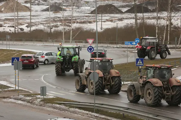 DAUGAVPILS, LATVIA - 5 Şubat 2024: Letonya 'da köylü protestosu. Traktörler, arabalar, tarım makineleri şehrin sokaklarında geziniyor.