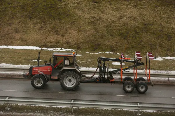 DAUGAVPILS, LATVIA - 5 Şubat 2024: Letonya 'da köylü protestosu. Traktörler, arabalar, tarım makineleri şehrin sokaklarında geziniyor.