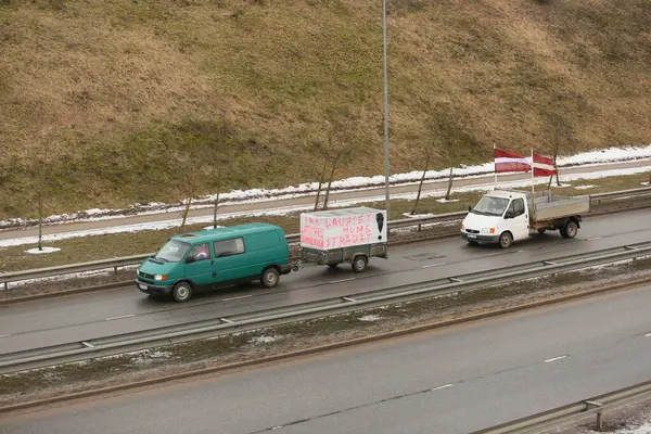 DAUGAVPILS, LATVIA - 5 Şubat 2024: Letonya 'da köylü protestosu. Traktörler, arabalar, tarım makineleri şehrin sokaklarında geziniyor.