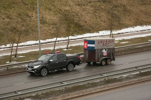 DAUGAVPILS, LATVIA - 5 Şubat 2024: Letonya 'da köylü protestosu. Traktörler, arabalar, tarım makineleri şehrin sokaklarında geziniyor.