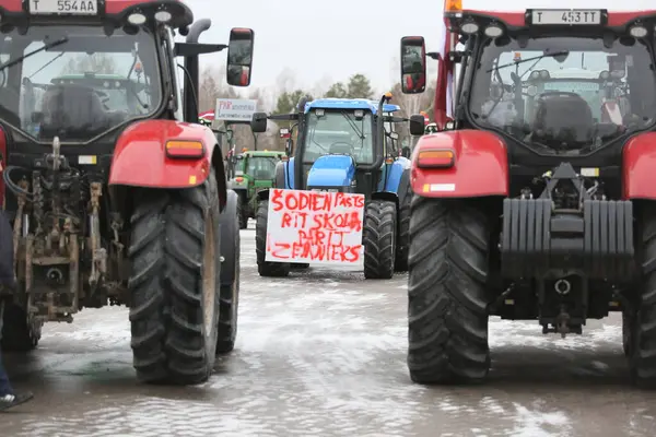 DAUGAVPILS, LATVIA - 5 Şubat 2024: Letonya 'da köylü protestosu. Traktörler, arabalar, tarım makineleri şehrin sokaklarında geziniyor.