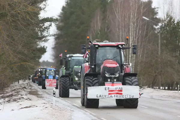 DAUGAVPILS, LATVIA - 5 Şubat 2024: Letonya 'da köylü protestosu. Traktörler, arabalar, tarım makineleri şehrin sokaklarında geziniyor.