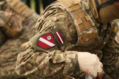 DAUGAVPILS, LATVIA - 17 Nisan 2024: Letonyalı asker. Letonya ordu bantlarıyla süslenmiş.