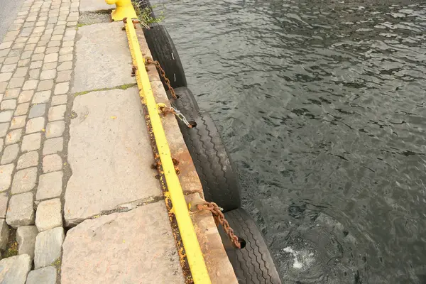 Stock image Pier lined with tires as fenders for the boats docking on them