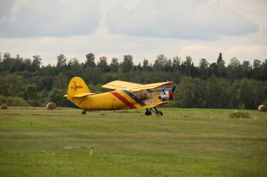 DAUGAVPILS, LATVIA - 27 Temmuz 2024 Sovyet uçak çift kanatlı Antonov AN-2 sarı gövde yeşil çimlere park edilmiş havaalanı yakın plan