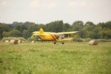 DAUGAVPILS, LATVIA - 27 Temmuz 2024 Sovyet çift kanatlı uçak Antonov AN-2 sarı gövde. Uçak kalkıyor.