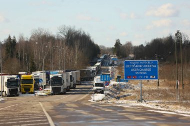 KRASLAVA BÖLGESİ, LATVIA - 17 Mart 2025: Letonya-Belarus sınırı. Paternieki 'den Letonya' ya giden yol. Bir kargo kamyonu kuyruğu