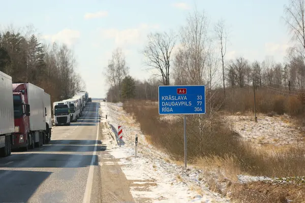 KRASLAVA BÖLGESİ, LATVIA - 17 Mart 2025: Letonya-Belarus sınırı. Paternieki 'den Letonya' ya giden yol. Bir kargo kamyonu kuyruğu
