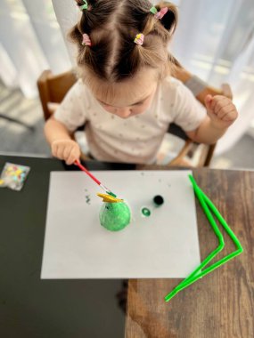 Kız suluboya resimler yapıyor, çocukların yaratıcılığı. Geleneksel Noel fındıkkıranları biblo süsü