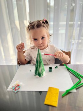 Kız suluboya resimler yapıyor, çocukların yaratıcılığı. Geleneksel Noel fındıkkıranları biblo süsü