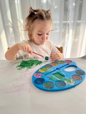 Kız suluboya resimler yapıyor, çocukların yaratıcılığı. Geleneksel Noel fındıkkıranları biblo süsü. 