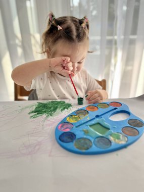 Kız suluboya resimler yapıyor, çocukların yaratıcılığı. Geleneksel Noel fındıkkıranları biblo süsü. 