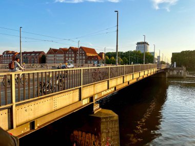 Bremen, Almanya - 11 Eylül 2024 - Uzak mesafede inşaat sahası ve vinçlerle birlikte Weser nehrinde kargo gemisi. 
