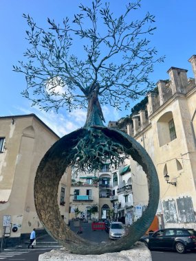 Amalfi Sahili, İtalya 13 Ekim 2024 Bir heykel ve Amalfi iskelesi boyunca yürüyen turistler. Yüksek kalite fotoğraf