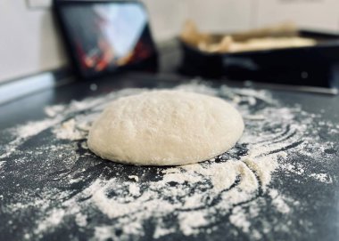 Çiğ hamur ve un siyah masada..