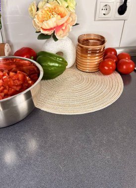 Dilimlenmiş Roman Domatesleri ve arka planda taze erik domatesleri, yumurta, fesleğen ve bir tabak pesto..