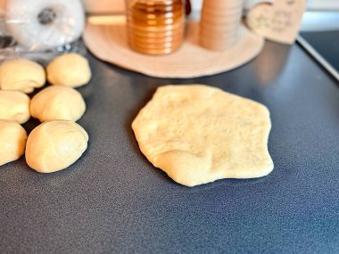 Kız kek veya kurabiye yapmak için hamuru ahşap bir oklavayla yuvarlıyor. Mutfak gereçleri ve malzemeleriyle düz kompozisyon, kopyalama alanı. Tatil için pişirme kavramı. 