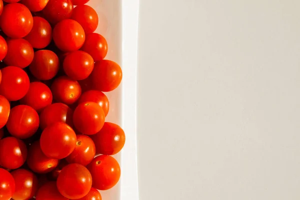 Cherry tomatoes. Cherry tomatoes in a white plate. Hard light. Bright light and shadow.