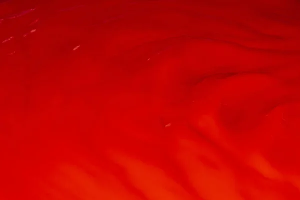 Red liquid, waves, fluidity.