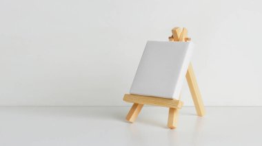 Mini painting on an easel on a light background. at an angle