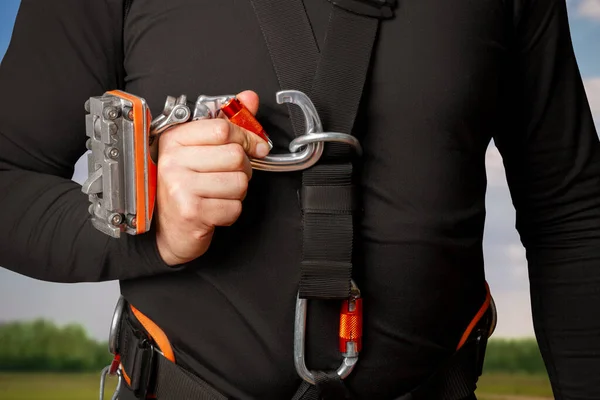 stock image Close-up personal insurance system. A man holds a carbine open. High-rise works, mountaineering, industrial mountaineering. Wind generators, towers, height. Isolated on white background.