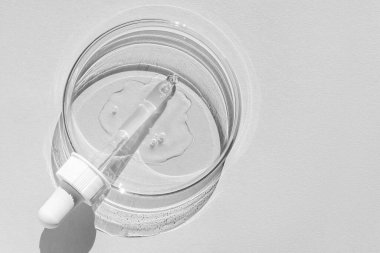 Petri kabı. Şeffaf jelle. Pipet yalan söylüyor. Kozmetik dağıtıcı. Beyaz bir arkaplanda.