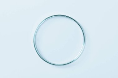 Mavi camdan yapılmış boş bir petri kabı. Mavi bir arkaplanda.