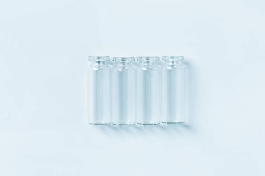 Mavi arka planda boş küçük mavi cam kavanozlar. Yukarıdan görüntüle.