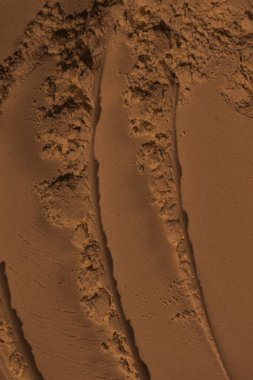 Kumun yüzeyi, kil, toprak. Tekerlek izleri, lastik izleri. Kraterler, çöküntüler, çıkıntılar. Mars. GezegenName