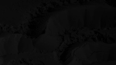 Siyah doku. Karanlık arka plan. Kum, toz, kömür, dalgalar, çizgiler, daireler. Dağlar. Çatlak, çatlak. Karanlık, karanlık, gölgeler.