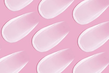 Arka plan kozmetik. Pembe arka planda bir sürü krema lekesi