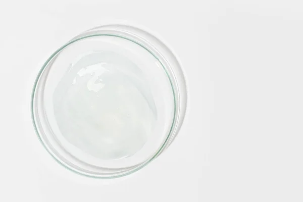 stock image Petri dish on a light background. With a smear of clear gel. Cosmetic gel, lubricant, gel. View from above