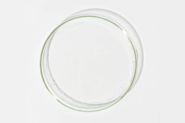 stock image Petri dish on a light background. With a smear of clear gel. Cosmetic gel, lubricant, gel. View from above