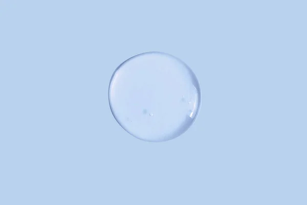 stock image Large round drop of transparent cosmetic gel on a blue, blue background