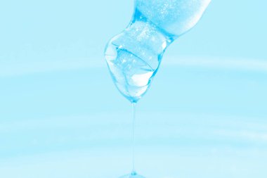 Damlayan mavi sıvılı boru. Ya da mavi sıvı. Yakın plan. Mavi arka planda. Laboratuvar, kimya, tıp. Kozmetik araştırması. Parla.