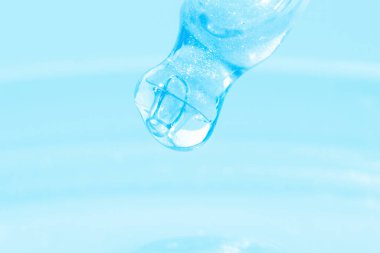 Damlayan mavi sıvılı boru. Ya da mavi sıvı. Yakın plan. Mavi arka planda. Laboratuvar, kimya, tıp. Kozmetik araştırması. Parla.